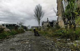 un la personne sur le rue de le détruit ville dans Ukraine photo