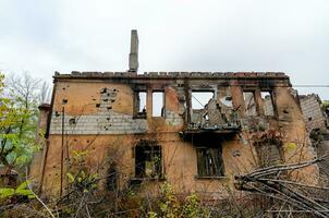 détruit et brûlé Maisons dans le ville pendant le guerre dans Ukraine photo