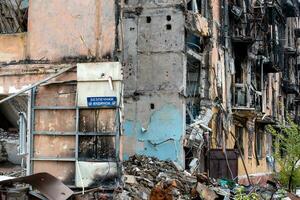 assiette texte dans ukrainien sûr maison sur le mur de une détruit et brûlé maison guerre dans Ukraine avec Russie photo