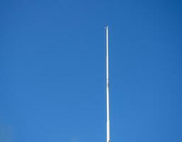vide blanc mât contre le bleu ciel. abaissé drapeau. photo