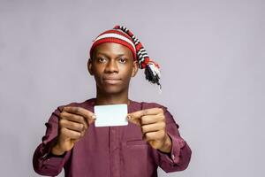 africain homme portant africain tenue robe en portant id carte moquer en haut avec tous les deux mains prêt à vote. sélectif concentrer photo