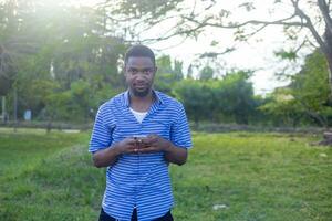 une souriant homme en portant une mobile téléphone et célébrer Succès photo