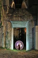 fille tenant une lanterne dans une porte en béton avec des vignes photo