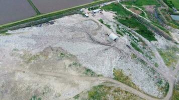 des ordures déverser avec des tas de des ordures et traitement installations. décharge de des ordures à l'extérieur le village photo