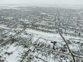 hiver vue de le des oiseaux œil vue de le village. le des rues sont couvert avec neige photo