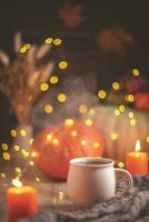 l'automne confortable composition. thé dans une tasse, citrouilles et bougies photo