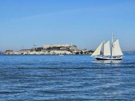 une voile bateau traversée dans de face de alcatraz île dans san francisco Californie photo