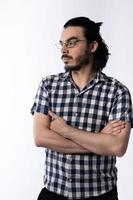 jeune homme avec barbe et lunettes croisant les bras et regardant de côté. avec fond blanc photo
