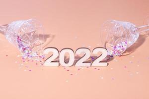plat festif du nouvel an avec des numéros 2022 et des ombres dures avec des lunettes et un décor brillant photo