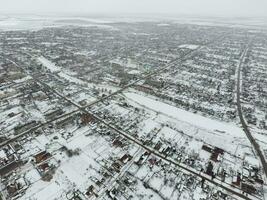 hiver vue de le des oiseaux œil vue de le village. le des rues sont couvert avec neige photo
