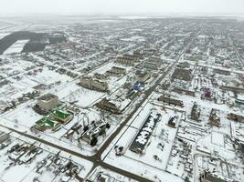 hiver vue de le des oiseaux œil vue de le village. le des rues sont couvert avec neige photo