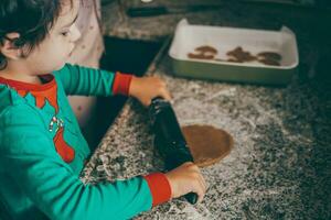 de fête atmosphère prend plus de maman et fils embarquer délicieux tâche de en train de préparer Noël pain d'épice photo