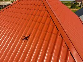 maison avec un Orange toit fabriqué de métal, Haut voir. métallique profil peint ondulé sur le toit. photo