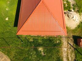 maison avec un Orange toit fabriqué de métal, Haut voir. métallique profil peint ondulé sur le toit. photo