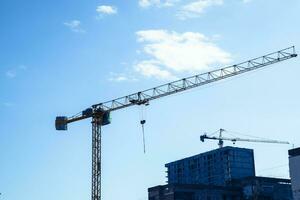 la tour bâtiment grue contre le bleu ciel et Soleil. construction de Nouveau bâtiments avec une grue. la tour grue photo