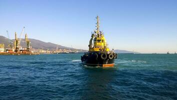 une petit un service navire dans une cargaison industriel port. une navire dans le mer photo