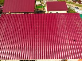 une maison avec une rouge toit fabriqué de ondulé métal feuilles. toit de ondulé métal profil. métal carrelage. photo