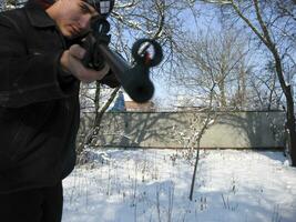 homme avec un air fusil dans une hiver parc. photo