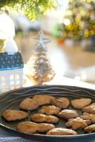 décor de noël festif à table, gâteaux faits maison pour le petit déjeuner, biscuits de boulangerie. maison confortable, arbre de noël avec des guirlandes de guirlandes lumineuses. nouvel an, ambiance de noël photo