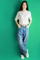 plein longueur portrait de une Jeune fille dans une blanc T-shirt et jeans. photo