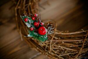 Noël rustique osier nid avec rouge baies sur en bois Contexte. photo