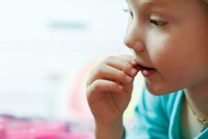 portrait de une peu fille en mangeant une Chocolat bonbons photo