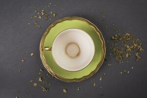 vert thé tasse sur une gris Contexte photo