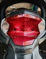 le moto les pièces. le moderne rouge frein lumière couverture vu de derrière photo