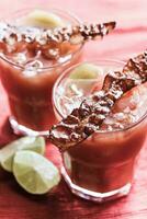 deux verres de bloody mary avec des tranches de bacon photo