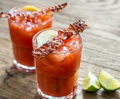 deux verres de bloody mary avec des tranches de bacon photo