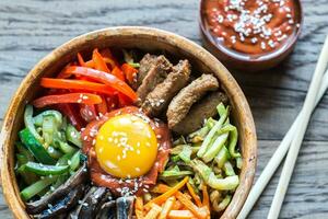 bol de Bibimbap sur le en bois table photo