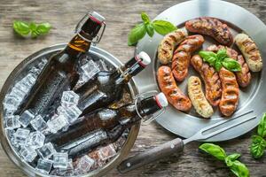 grillé saucisses avec bouteilles de Bière photo