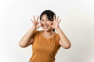 le de bonne humeur Jeune asiatique femme souriant et montrant le D'accord main signe permanent sur blanc Contexte. photo