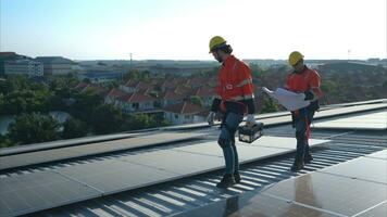 tous les deux de techniciens est installation solaire panneaux sur le toit de le entrepôt à changement solaire énergie dans électrique énergie pour utilisation dans des usines. photo