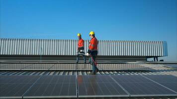 tous les deux de techniciens est installation solaire panneaux sur le toit de le entrepôt à changement solaire énergie dans électrique énergie pour utilisation dans des usines. photo