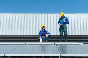 tous les deux de techniciens est installation solaire panneaux sur le toit de le entrepôt à changement solaire énergie dans électrique énergie pour utilisation dans des usines. photo