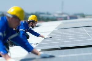 tous les deux de techniciens est installation solaire panneaux sur le toit de le entrepôt à changement solaire énergie dans électrique énergie pour utilisation dans des usines. photo