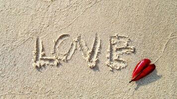 l'amour inscrit sur le sable avec cœur feuille photo