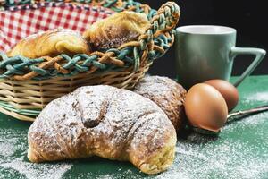 fraîchement cuit des croissants avec en poudre sucre sur une rustique table photo