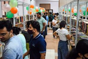 Delhi, Inde, septembre 09 2023 - divers âge groupe gens en train de lire variété de livres sur étagère à l'intérieur une kiosque à delhi international livre équitable, sélection de livres sur afficher dans annuel livre juste photo