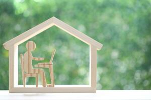 homme en utilisant portable ordinateur dans modèle maison sur Naturel vert arrière-plan, entreprise investissement et réel biens concept photo