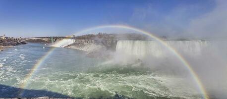 panoramique image plus de niagara chutes avec bleu ciel et arc en ciel dans été photo