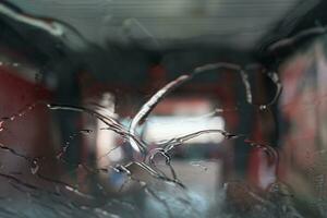 à la recherche en dehors par l'eau sur une verre pare-brise dans voiture laver. photo