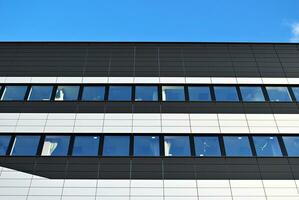 abstrait fermer de le revêtu de verre façade de une moderne bâtiment couvert dans réfléchissant assiette verre. architecture abstrait Contexte. verre mur et façade détail. photo