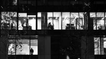 modèle de Bureau bâtiments les fenêtres illuminé à nuit. verre architecture , d'entreprise bâtiment à nuit - affaires concept. noir et blanche. photo