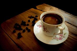 tasse de café et de grains sur une vieille table en bois photo