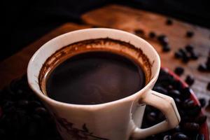 tasse de café et de grains sur une vieille table en bois photo