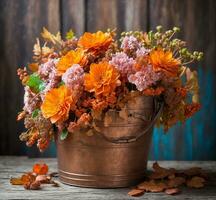 ai généré une bouquet de l'automne fleurs dans une cuivre seau sur une en bois Contexte photo