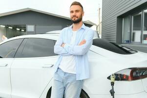 homme mise en charge électrique voiture par le maison. photo