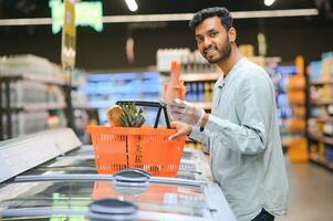 portrait de Indien Masculin dans épicerie avec positif attitude photo